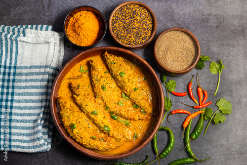 A rich, spicy Bengali dish featuring soft pabda fish simmered in a flavorful mustard-tomato gravy. photo