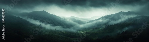 Mysterious landscape with dark mountains shrouded in mist, creating an atmospheric and dramatic scene in nature.