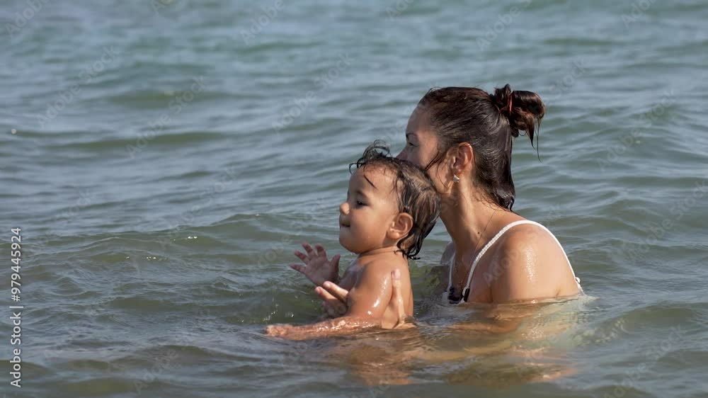 Mother with her daughters enjoying summer day on beach. Young woman with children swimming on a beach Mother with her daughters enjoying summer day on beach. Young woman with children swimming on a beach