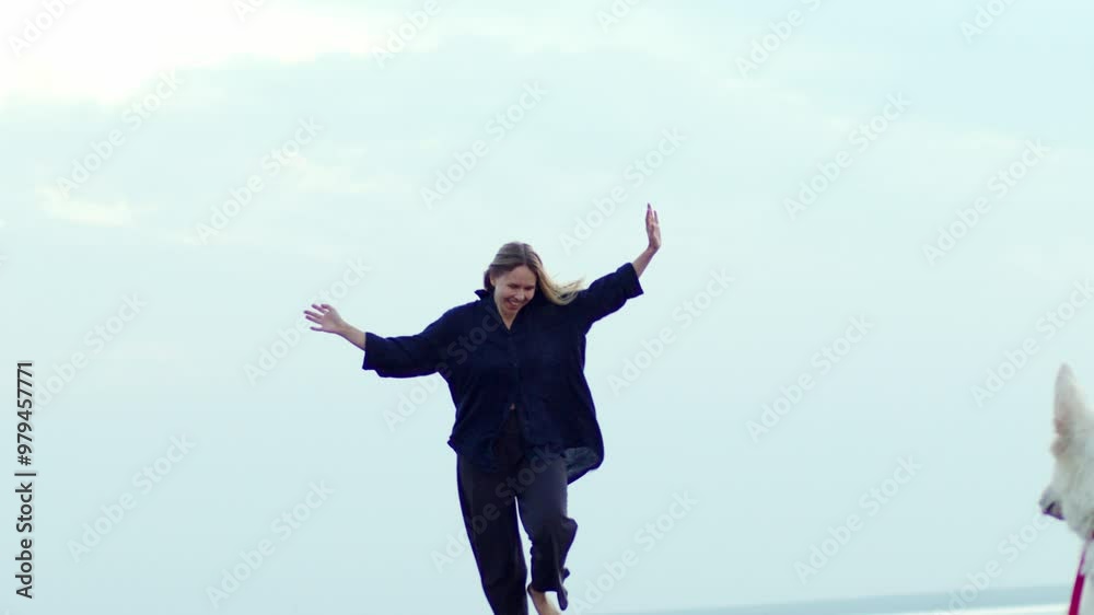A joyful girl in a dark blue linen suit runs towards the camera with the sky in the background, heading towards a dog. Every day can be the start of change. Live life today. A joyful girl in a dark blue linen suit runs towards the camera with the sky in the background, heading towards a dog. Every day can be the start of change. Live life today.