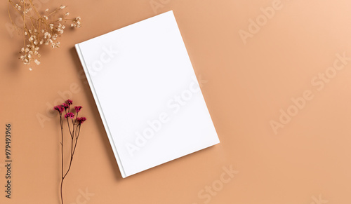 Εκτύπωση καμβά Mockup of a white hardcover book on a brown dark beige background dried gypsophila flower