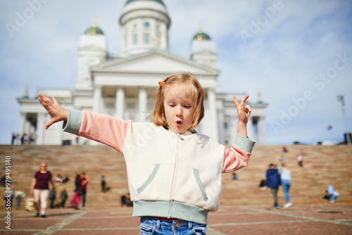 Adorable preschooler girl near Helsinki Cathedral (Helsingin tuomiokirkko) on Senaatintori in Helsinki, Finland photo