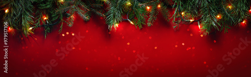 Christmas fir branches on glittering red background with winter holiday lights