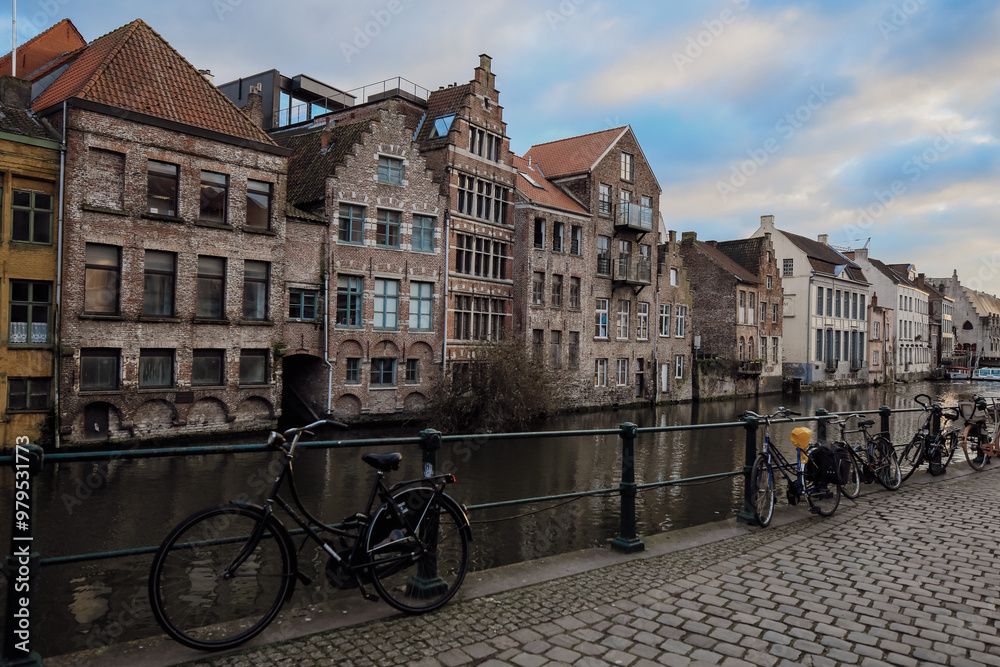 Fototapeta premium Exploring the charming canals and historic architecture along the banks in Ghent, Belgium during a tranquil afternoon stroll