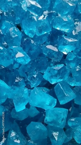 Close up of multiple shiny blue crystals, showing intricate details and reflections.