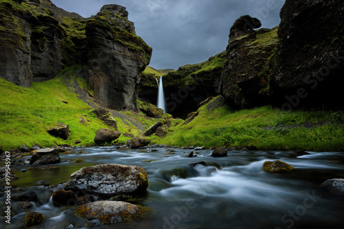 View of Kvernufoss waterfall surrounded by majestic rocks and greenery in a beautiful canyon, Skogafoss, Iceland. photo