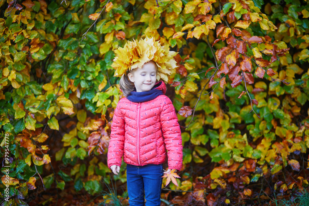 Adorable preschooler girl in maple leaves head decoration enjoying nice and sunny autumn day outdoors. Happy child walking on a fall day in Paris, France. Adorable preschooler girl in maple leaves head decoration enjoying nice and sunny autumn day outdoors. Happy child walking on a fall day in Paris, France.