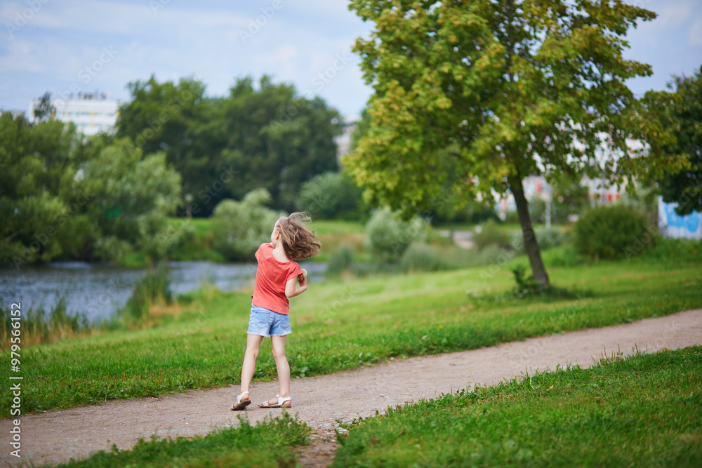Adorable preschooler girl having fun in a green park on a summer day. Adorable preschooler girl having fun in a green park on a summer day.