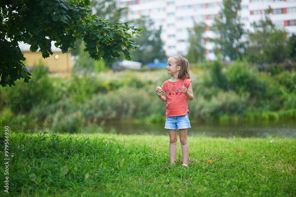 Adorable preschooler girl having fun in a green park on a summer day. Adorable preschooler girl having fun in a green park on a summer day.