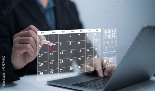 Businessman pointing pen of virtual screen schedule (timetable) on calendar to make appointment meeting Project management concept , analyst working with computer in management system to make report