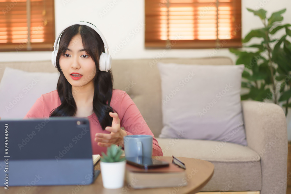 Young businesswoman in headphone explaining business data with partners while meeting in video call Young businesswoman in headphone explaining business data with partners while meeting in video call
