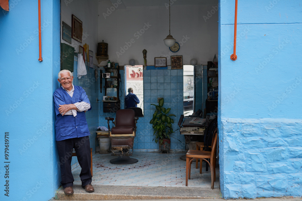 Fototapeta premium Barber shop, senior man and portrait with pride for beard trim, cutting and hair care for customer service. Small business, male owner and hairdresser in salon with confidence, smile and entrepreneur