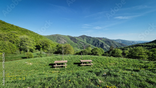 Paysage de montagne en Espagne, avec des arbres et des bancs.