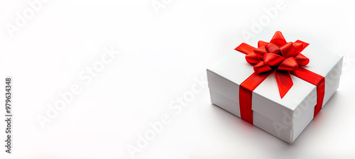 A white box with a red bow on top. The box is decorated with a red ribbon. The concept of celebration and joy.