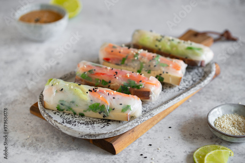 Summer rolls with fresh vegetables and smoked tofu served with peanut sauce and lime. Vietnamese appetizer. Spring rolls. Healthy food concept. Snacks, finger food. Close up. photo