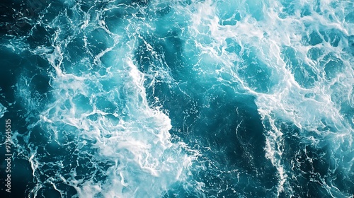 Aerial view of turbulent ocean water with vibrant blue and white waves.