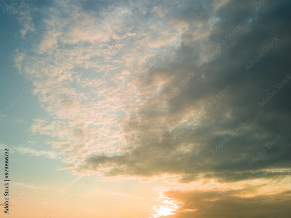 Obraz premium The rays of the sun breaking through the dramatic clouds in the evening or in the morning in the sunset or sunrise sky.