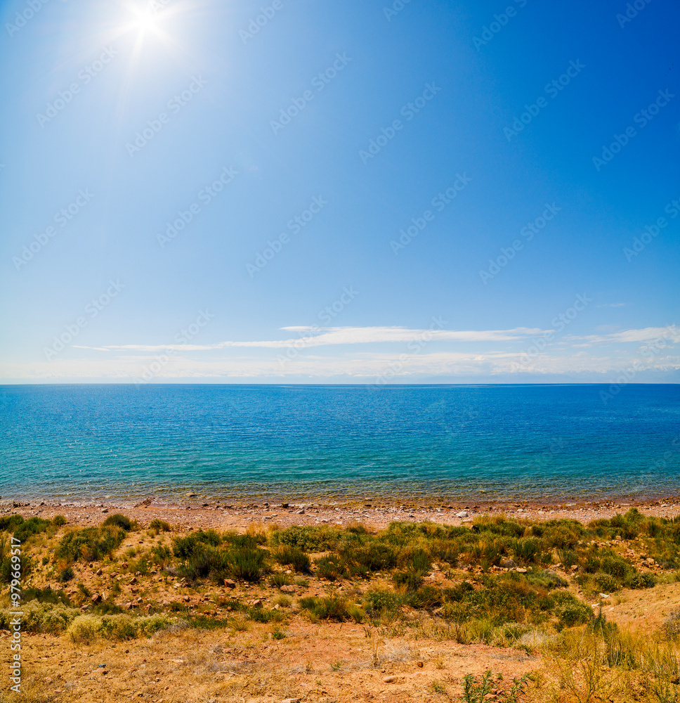 large open water surface with far snowcapped mountain range on the horizon at sunny day. large open water surface with far snowcapped mountain range on the horizon at sunny day.