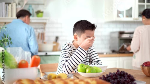 Happy Asian family with farther, mother, and son are enjoy eating a breakfast together in kitchen,  photo