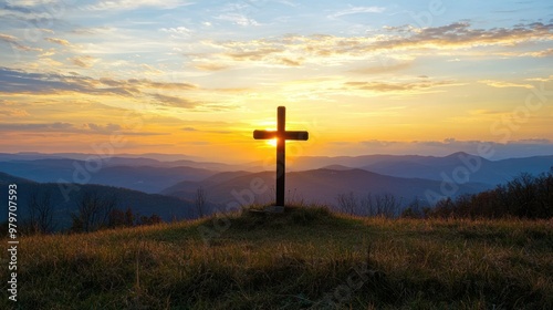 A cross on a hilltop with sunrise in the background.