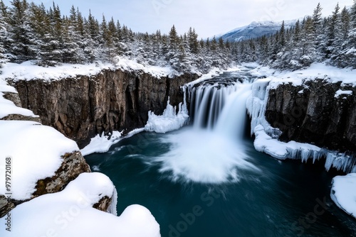 Majestic waterfall surrounded by snow-covered trees, creating a peaceful winter wonderland