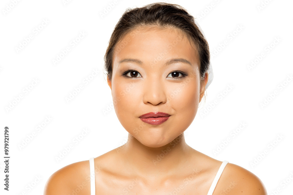 Portrait of a beautiful young smiling Asian woman posing with makeup on white studio background. Portrait of a beautiful young smiling Asian woman posing with makeup on white studio background.