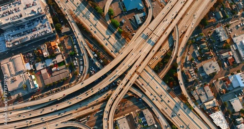 Hundreds of cars moving by the roads of a huge interchange. Aerial perspective on the traffic system of Los Angeles, California, US.