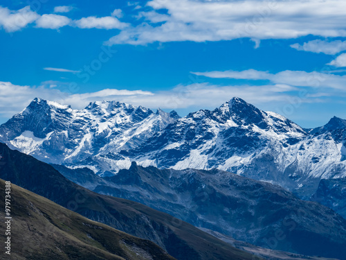 massif de la vanoise vu de puis le massif du beaufortain, avec une succession de crêtes, alpages, neige sur les sommets, en panorama