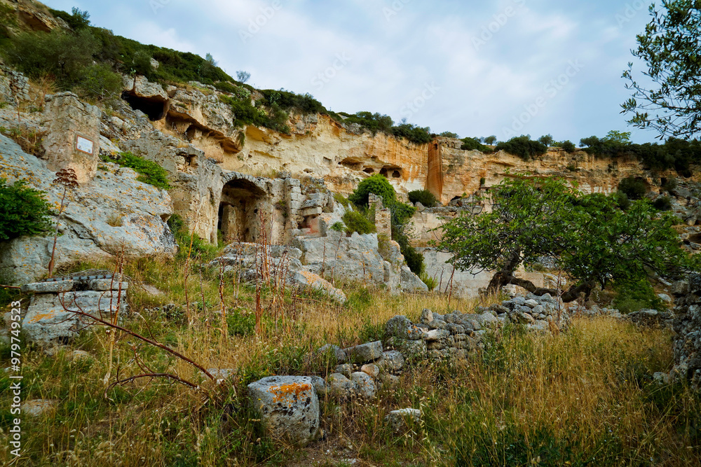 Fototapeta premium Il nucleo antico di Ginosa caratterizzato dalla gravina con antiche case e chiese rupestri, Taranto, Puglia, Italia