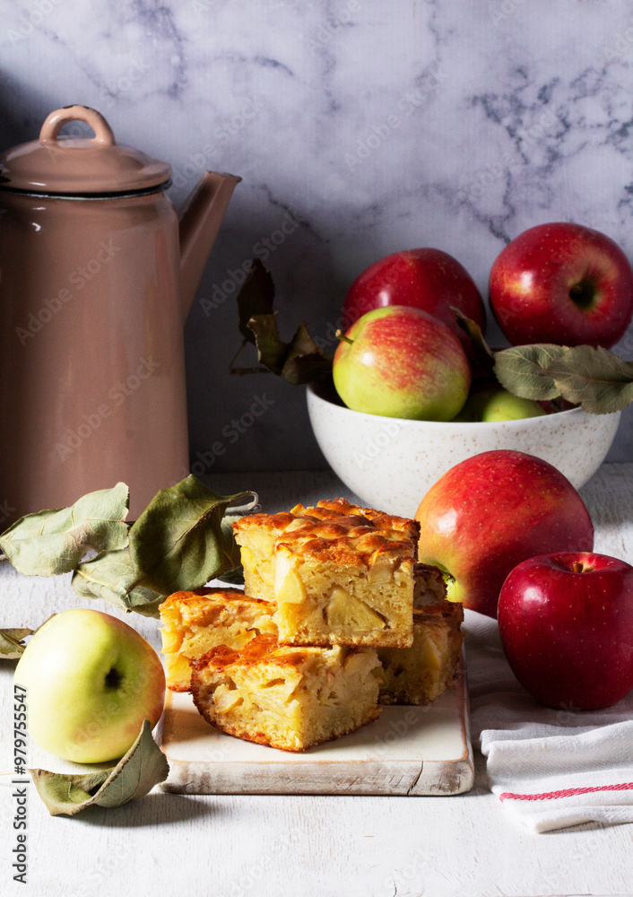 Apple pie, apples and teapot served for tea. Traditional apple dessert.