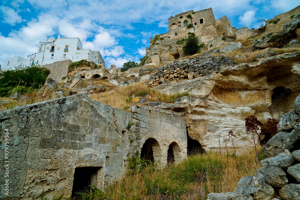 Fototapeta premium Il nucleo antico di Ginosa caratterizzato dalla gravina con antiche case e chiese rupestri, Taranto, Puglia, Italia