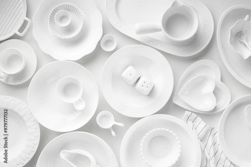 Set of White Porcelain dishes of various form and size on white background. Overhead image, copy space. Monochrome background Set of White Porcelain dishes of various form and size on white background. Overhead image, copy space. Monochrome background
