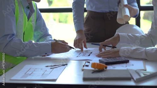 Engineering Team Brainstorming: A close-up of a team of engineers collaborating on blueprints, showcasing their dedication and teamwork. The image captures the focus and intensity of their brainstormi photo