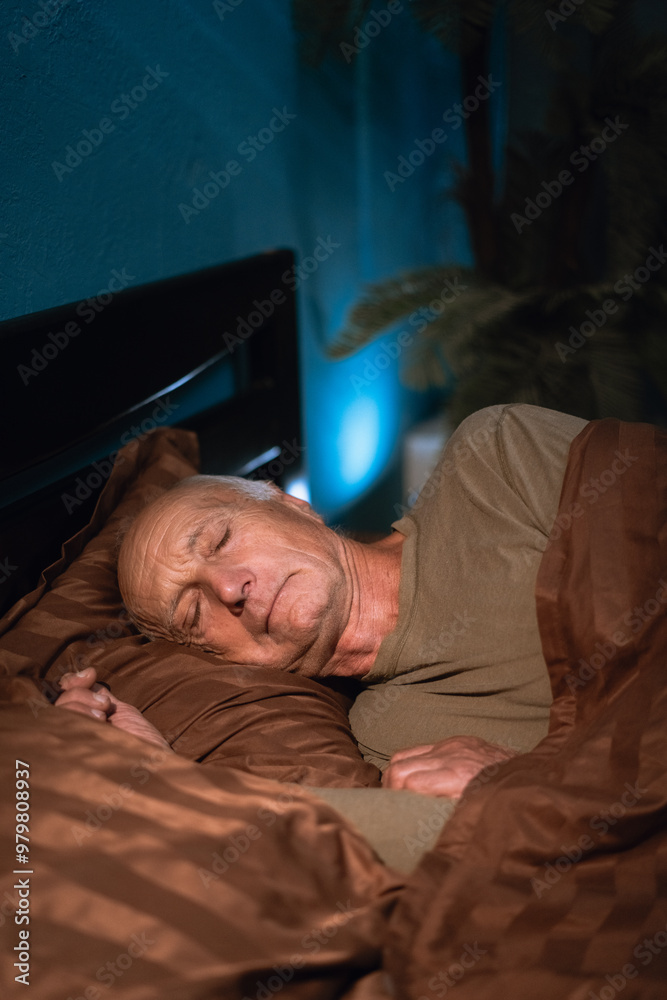 old calm man appears relaxed and comfortable, with her eyes closed, resting or sleeping at night in his bed at home old calm man appears relaxed and comfortable, with her eyes closed, resting or sleeping at night in his bed at home