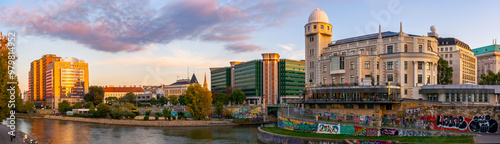 vienna, austria - 17 oct 2019: donaukanal embankment panorama in autumn. urania observatory beautiful architecture and trees in fall season at sunset. urban scenery near aspernbrucke in evening light