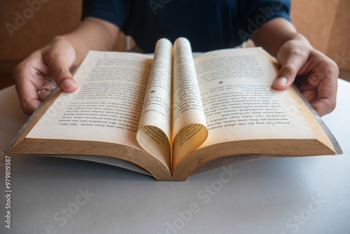 close up of woman's hand holding a book. book paper forms love