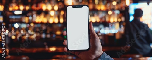 hand holding a smartphone with a blank screen in a lively bar with colorful shelves of bottles in the background