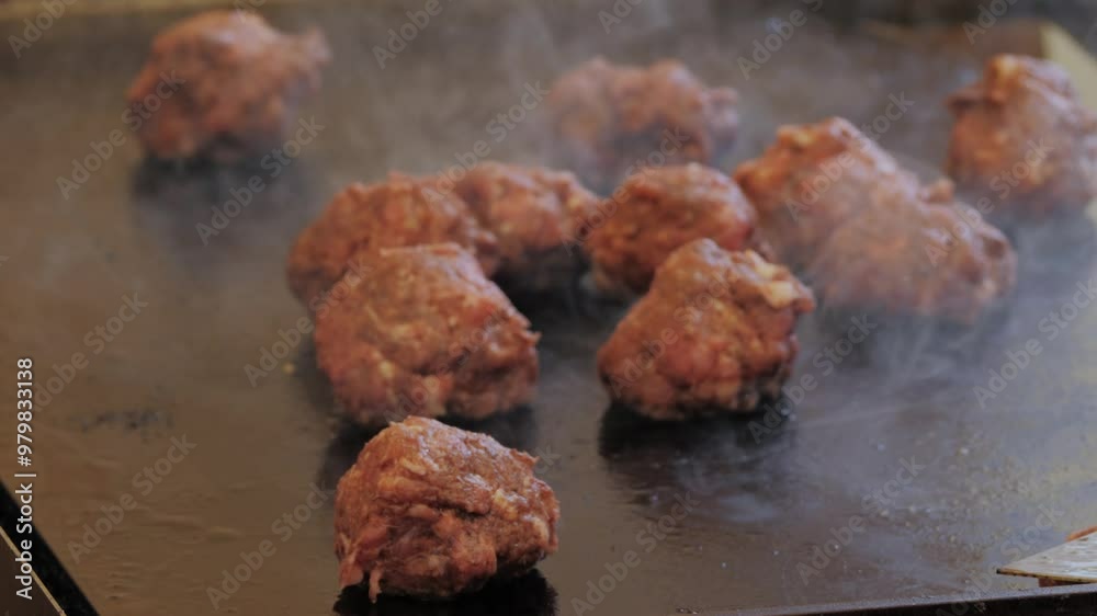 Cooking American fat smash burger with fresh onion on top on grill close-up. Beef or pork cutlet smashing by burger press. The chef in kitchen of the restaurant making Cooking American fat smash burger with fresh onion on top on grill close-up. Beef or pork cutlet smashing by burger press. The chef in kitchen of the restaurant making