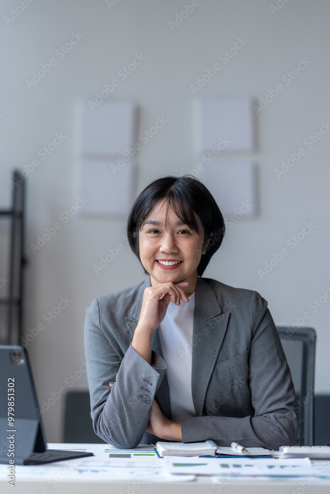 Confident asian businesswoman smiling while working at her desk Confident asian businesswoman smiling while working at her desk