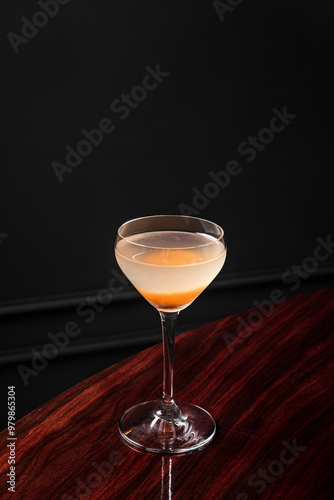 An alcoholic cocktail in coupe glass with apricot garnish