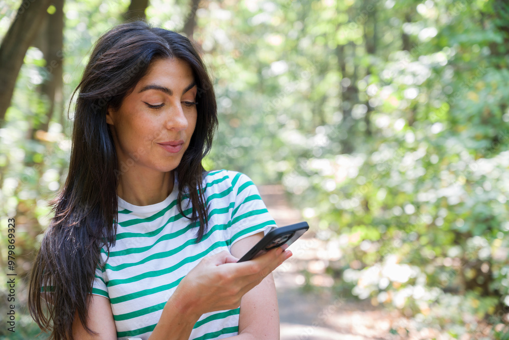 Portrait of beautiful young woman looking her phone in the city park Portrait of beautiful young woman looking her phone in the city park