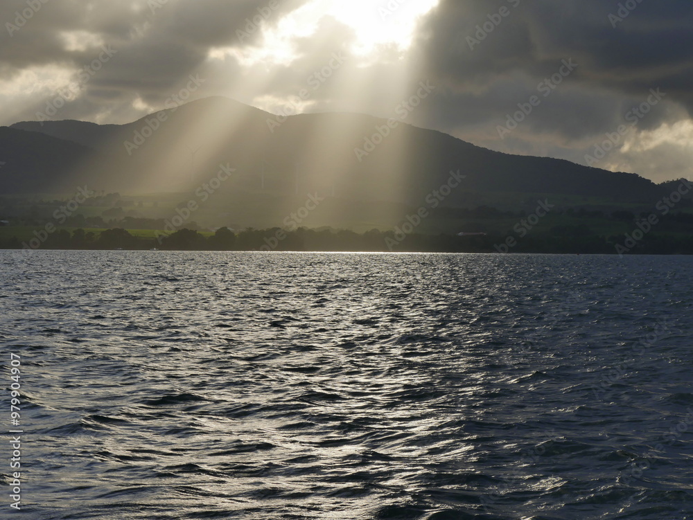 sunrays over mountain in stormy weather in Sainte rose, Basse terre, guadeloupe seen from grand cul de sac marin sunrays over mountain in stormy weather in Sainte rose, Basse terre, guadeloupe seen from grand cul de sac marin