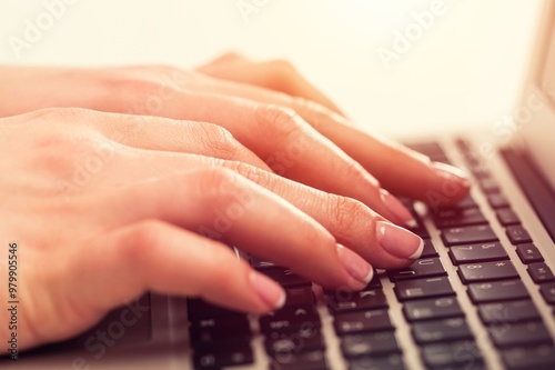 A man typing on a laptop computer keyboard