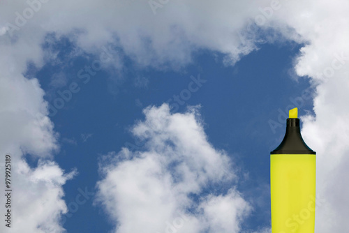 Yellow highlighter against a blue sky with clouds