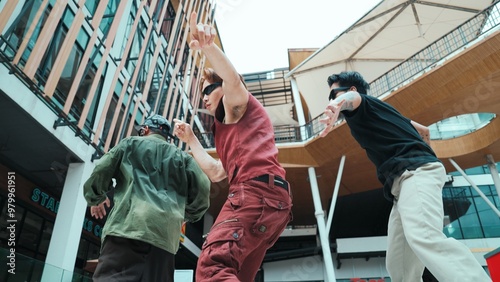 Asian hip-hop dancer group practicing foot step with dancing team. Attractive hipster group perform street dance or break dance at mall or city. Low angle view. Outdoor sport 2024. Hiphop. photo