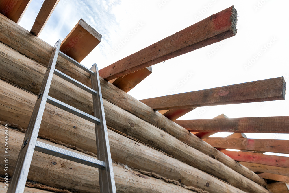 Rural wooden house house is under construction. A ladder goes up to the wall Rural wooden house house is under construction. A ladder goes up to the wall