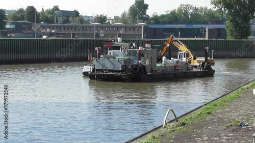 cargo ship with an excavator wirking in the river photo