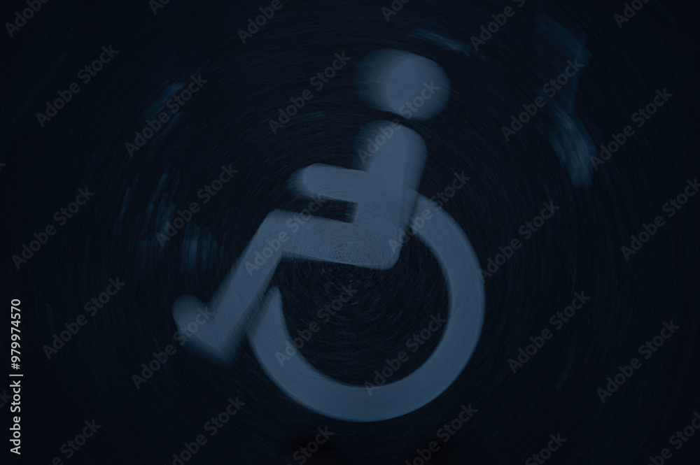 blurred wheelchair symbol on a dark asphalt