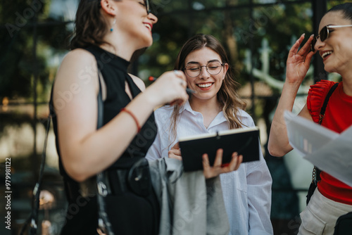 Three businesswomen having a casual meeting outdoors, discussing and sharing ideas. They are smiling and enjoying their conversation.