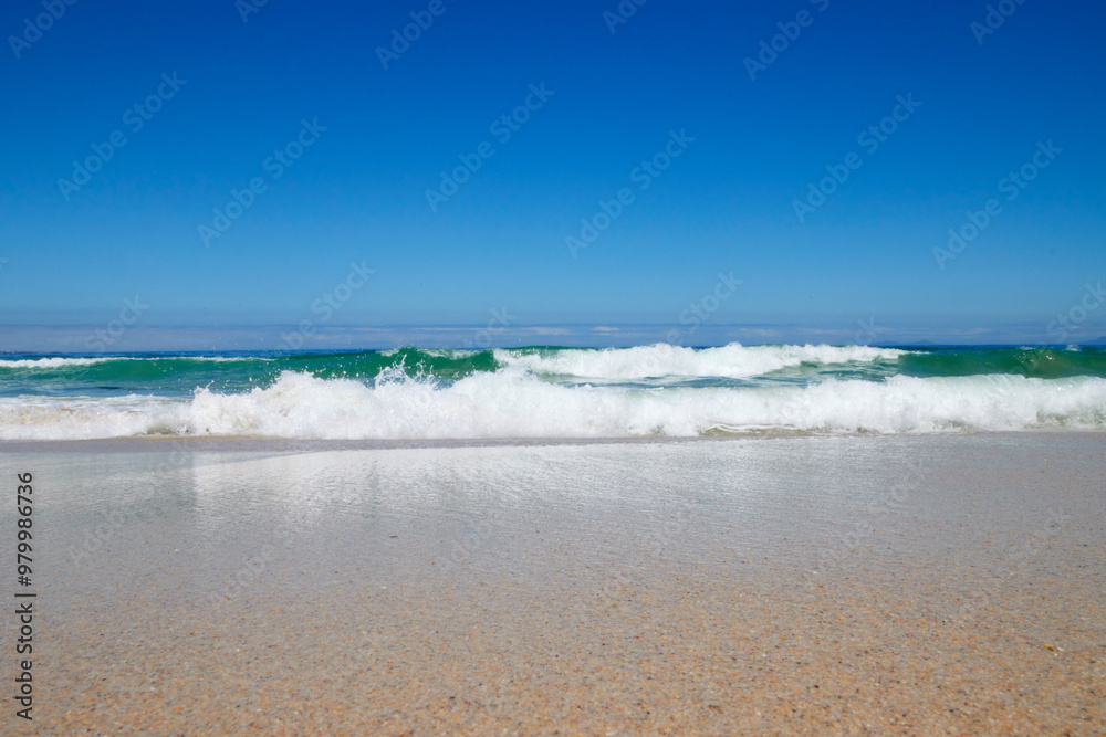 Obraz premium Welle am Strand bei blauem Himmel